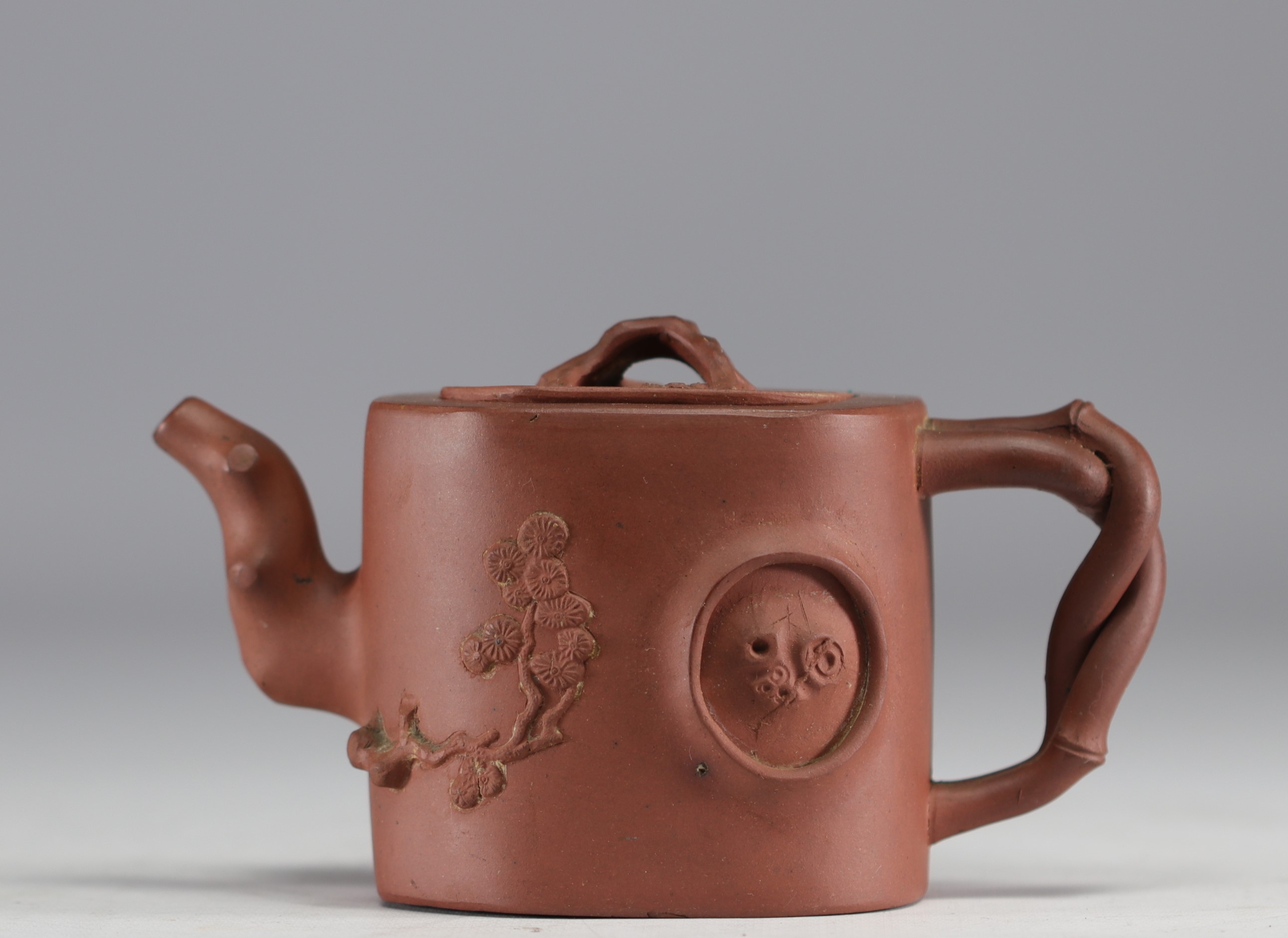China - Yixing teapot in terracotta with floral decoration in relief, debossed mark on the underside