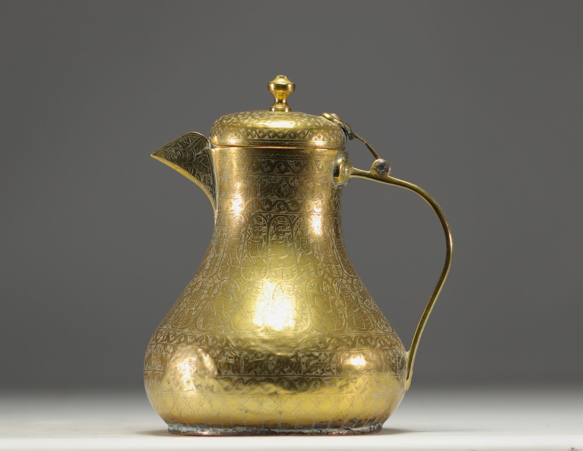 Persian coffee pot in chased brass with animal and figure motifs.