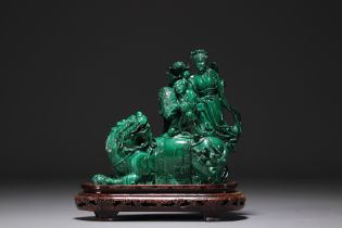 China - Malachite sculpture representing a Fo dog and characters, on a wooden base.