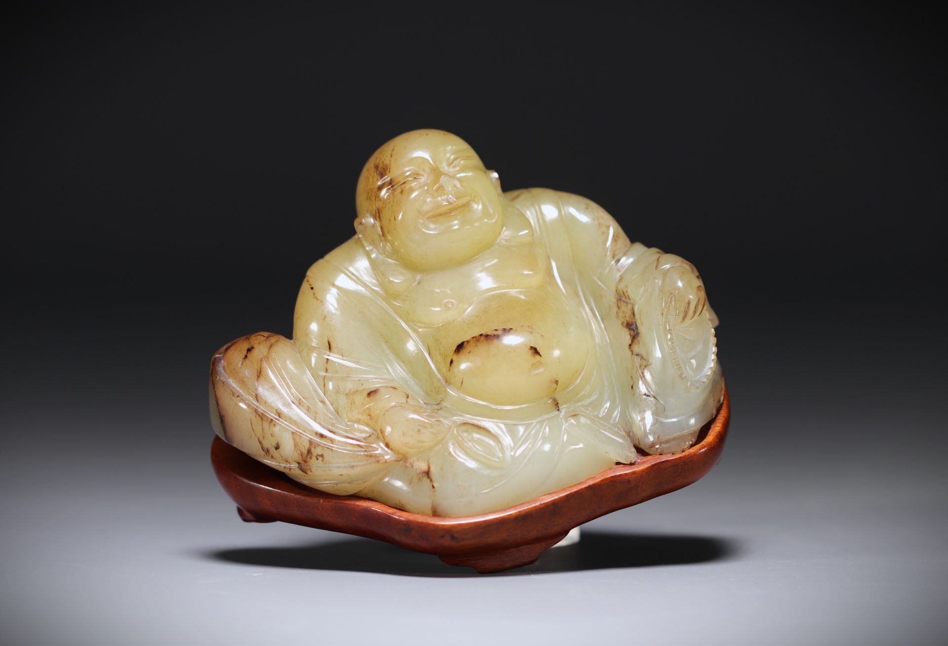 China - Green/brown jade Buddha on base.