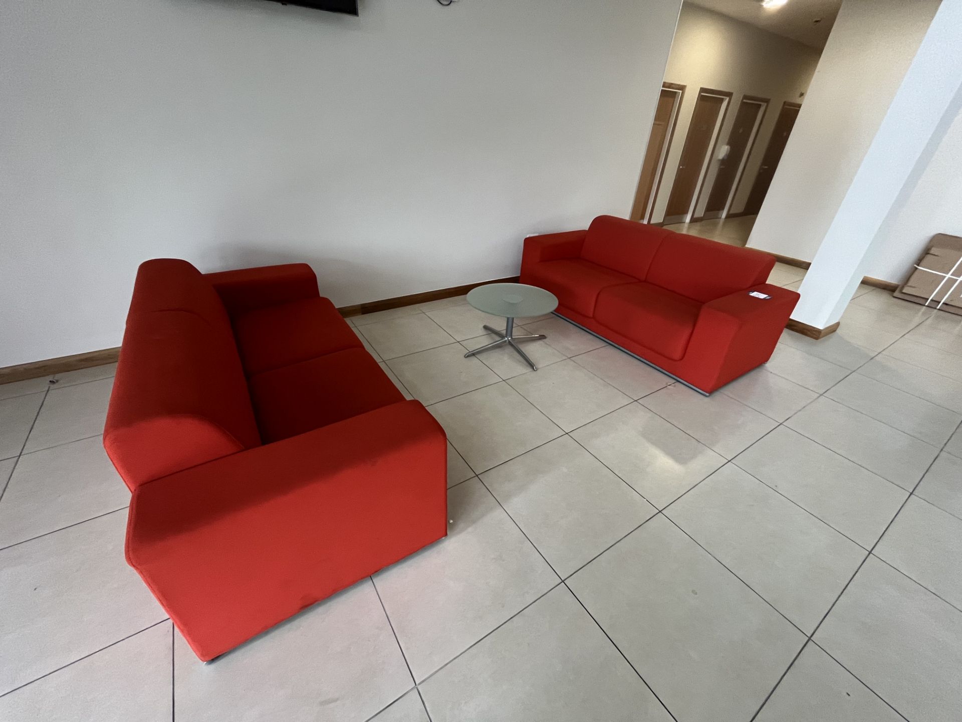 2x (no.) orange cloth upholstered two seater sofas and glass circular occasional table