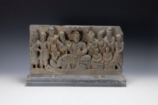 A Gandharan Grey Stone Frieze of a Buddha. Approximately 44.5 x 23cm