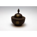 An Islamic Qajar Bowl with a Lid with Islamic Calligraphy in Gold Inlay.

Approximately 20 x 17cm 