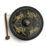 Burmese black lacquered metal nipple gong decorated with four gilt figures, diameter 25cm. With