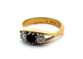 A 22ct gold, sapphire and diamond ring, size R. Central sapphire of approx 4.2mm diameter is flanked