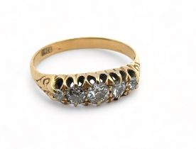 An old cut diamond five stone ring with scroll shoulders, size Q. 3.2g.