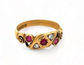 An 18ct gold ruby and diamond gypsy ring with scroll shoulders. Size P. Birmingham 1907 hallmarks.