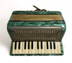 A Hohner Mignon II Accordion. Turquoise. Appears to be playing.