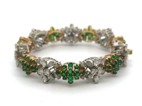 An emerald and diamond bracelet with alternate links of diamonds and emerlads. The 7 diamond links