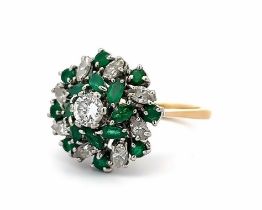 An 18ct and platinum emerald and diamond cluster ring. The principal diamond estimated at 0.36ct