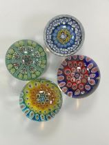 Four vintage glass paperweights to include; Strathearn, millefiori designs. Diameters from 7cm to