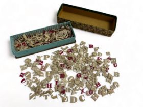 A box containing a quantity of bone alphabet letters (likely 19th Century), some natural some