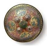 Indian/Persian brass and red enamel circular dhal shield, typically domed and centred by four