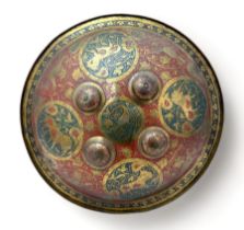 Indian/Persian brass and red enamel circular dhal shield, typically domed and centred by four