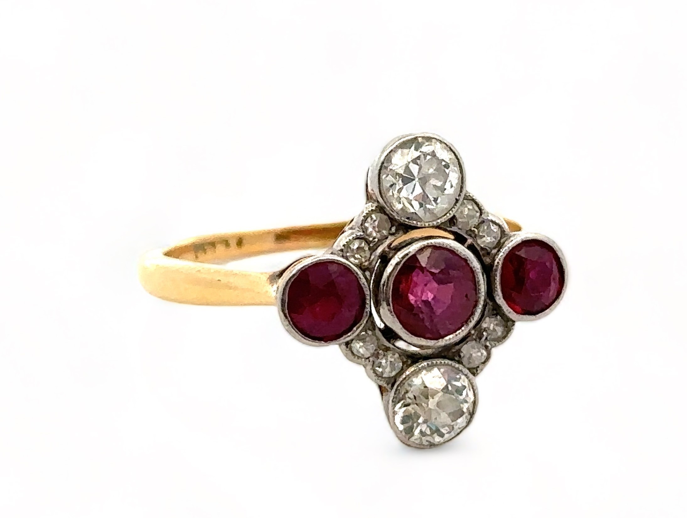 A ruby and diamond quatrefoil ring, size N, stamped 18ct. Two old cut diamonds each approx 0.3ct,