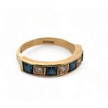 An 18ct gold, diamond and synthetic sapphire seven stone ring, size N. Weight 4.48g.