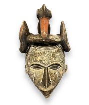 Very Impressive Hand Carved Tribal Mask depicting bird on a warriors head with snake in it's bill.