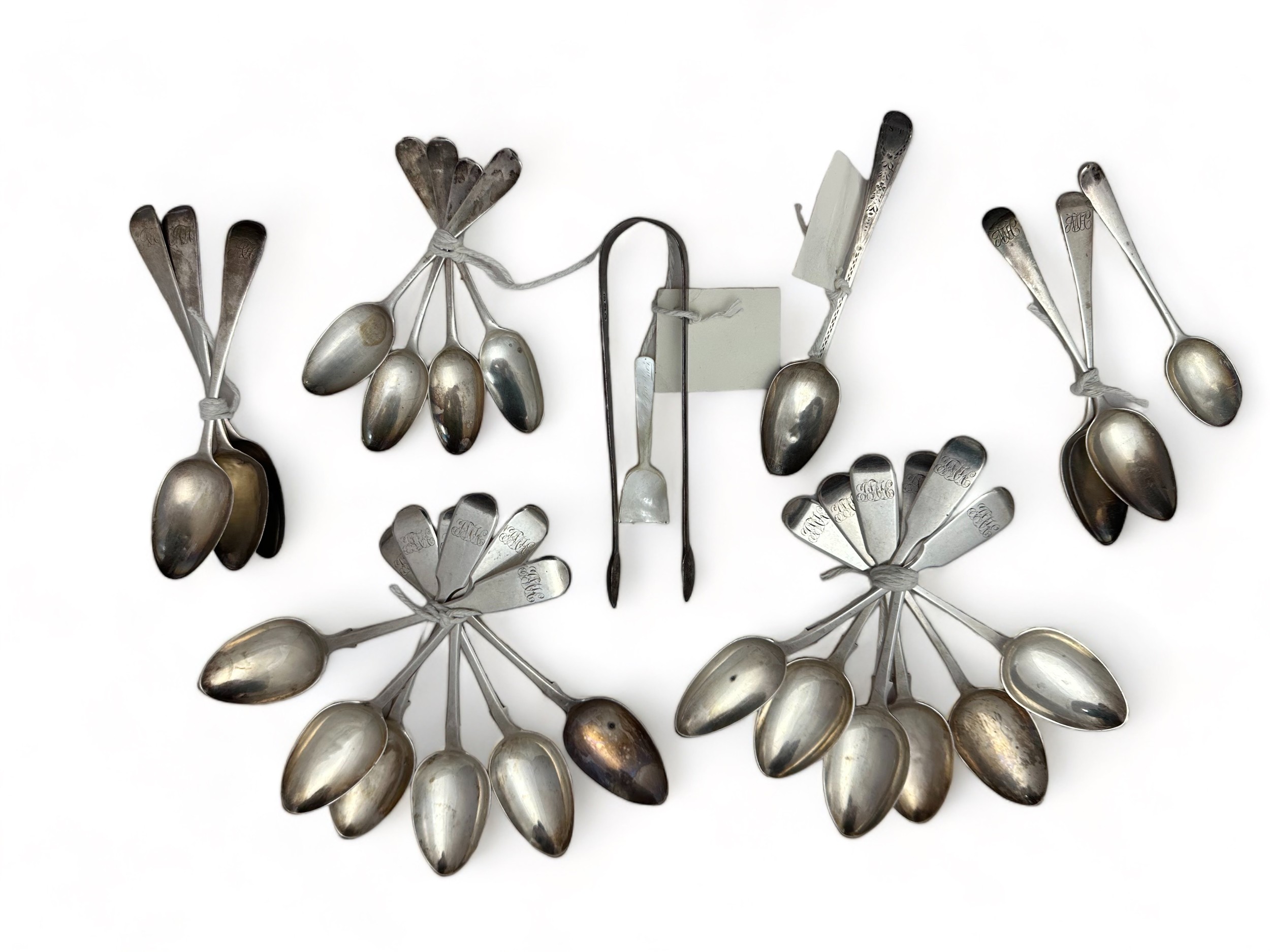 Silver tea spoons, table spoons and sugar tongs. Includes a set of twelve dessert spoons by