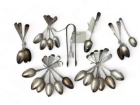 Silver tea spoons, table spoons and sugar tongs. Includes a set of twelve dessert spoons by