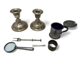 A range of silver and white metal items: includes a weighted pair of candle holders with marks for