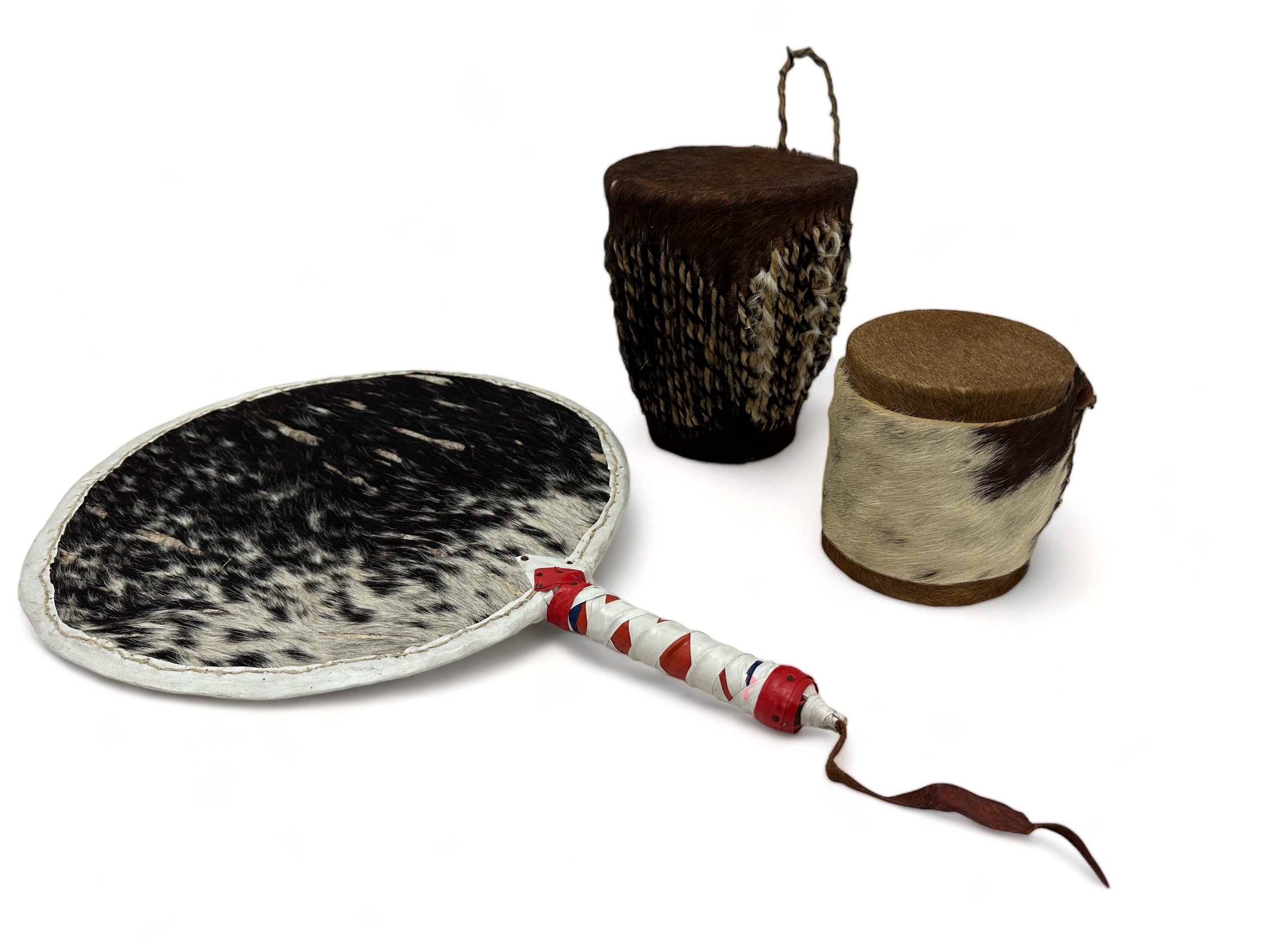 Two African Dundun drums and an animal hide fan. Fan 47 x 33 cm, Drums 18cm and 12.5cm high.