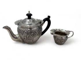 A repousse sterling silver bachelor teapot and cream jug by Frederick William Tomkins Turton. Teapot