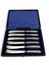 A cased set of six butter knives with EPNS blades and filled silver handles. Hallmarks for William