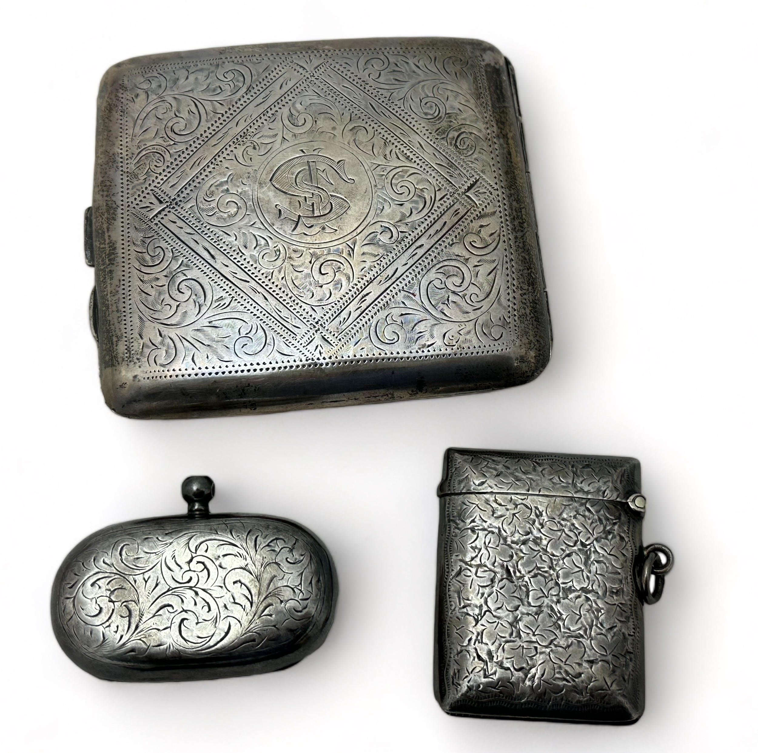 Three silver items: cigarette case, sovereign holder and vesta case. Engraved cigarette case with