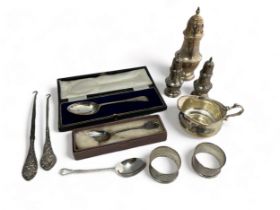 A range of hallmarked silver items, including a cream jug, sugar sifter, salt and pepper shakers,