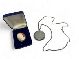 A cameo brooch depicting a lady in profile, stamped 800, and a 1965 Churchill commemorative crown in