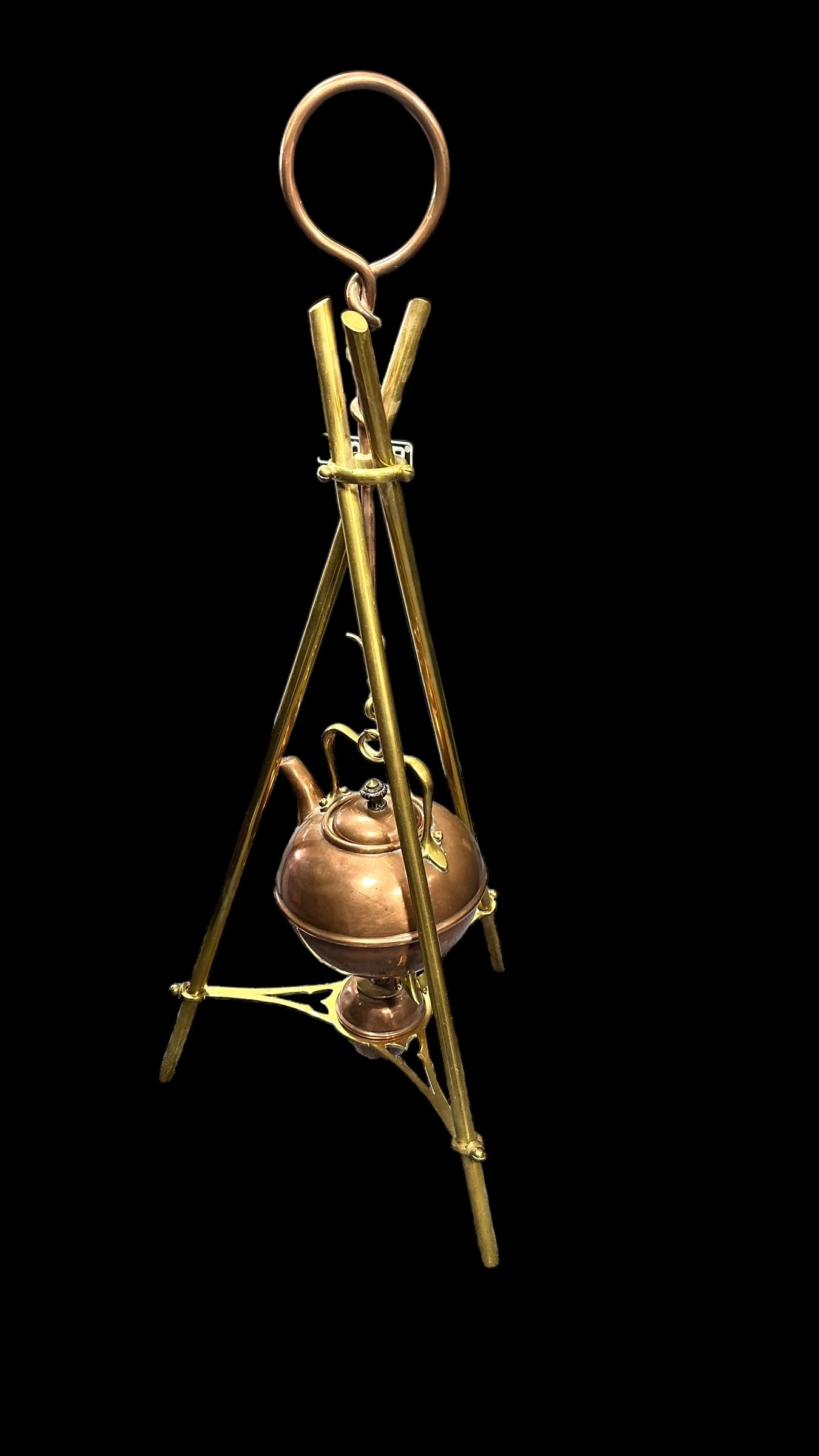 Arts and Crafts brass and copper hanging kettle, stood on three tripod legs. Unsigned. Height 70cm.