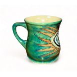 Moorcroft pottery mug decorated to a design by Sally Tuffin with a peacock feather, for Liberty