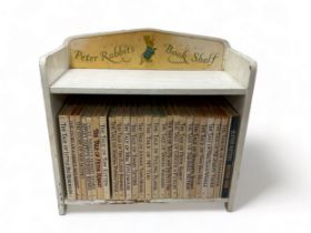 A wooden Peter Rabbit Book Shelf containing 25 Beatrix Potter books.