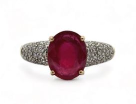 A 9ct yellow gold ring set with a central ruby and diamond shoulders. Size N. Weight 3.8g. In