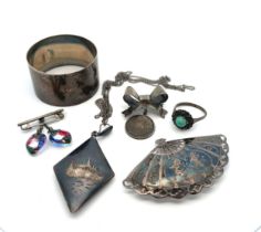 Small collection of silver and silver jewellery items. Includes a napkin ring, a bow brooch with a