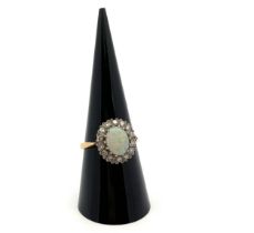 An 18ct yellow gold, opal and diamond ring. Opal (approx 9mm x 6mm) with full spectrum of colour