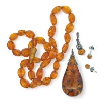 An amber bead necklace, two amber pendants and a pair of amber stud earrings. The smaller pendant