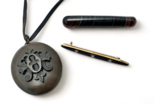 Three items of Victorian mourning jewellery including an agate brooch, a bar brooch and a bog oak