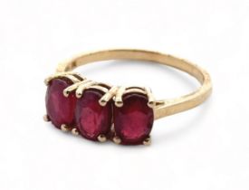 A three stone ruby ring in 9ct yellow gold. Size S. In very good condition. Please see the buyer's