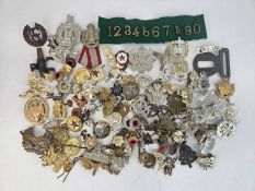 A large accumulation of British Army and foreign cap badges, buttons and cloth badges, together with