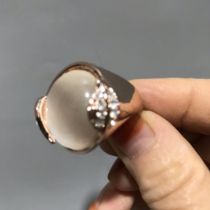 A white gemstone cat's eye inlaid ring