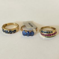 A collection of three 9ct yellow gold gem set rings. Featuring an emerald, ruby and sapphire dress