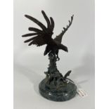 A bronze group of an eagle about to catch a leaping salmon. Approximately 25cm tall with good