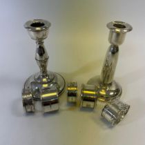 5 Silver napkin rings and 2 candlesticks.  Silver weight approximately 70 grams.  Candlesticks