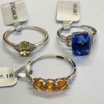 A group of three 9ct white gold rings to include an orange garnet ring, size U; a colour change