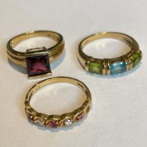 A group of 9ct gold gem set rings. Featuring a square cut garnet ring, a topaz and peridot ring