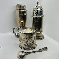 A collection of silver comprising two sugar casters, a mustard pot and and a mustard spoon.