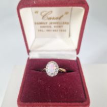 A 9ct gold opal and diamond cluster ring.  Featuring a central opal cabochon, measuring