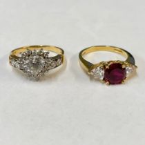 Two 14ct yellow gold stone set rings. Featuring a verneuil flame fusion synthetic ruby, flanked by