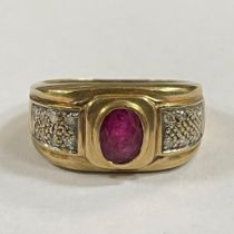 A 9ct yellow gold diamond and ruby ring. The ruby is an oval mixed cut measuring 7mm x 5mm face